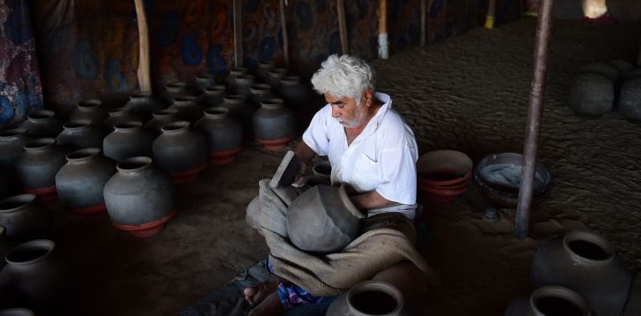 Un alfarero fabrica una vasija de arcilla para almacenar agua en un taller en las afueras de Ahmedabad, India.