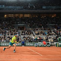 El español Rafael Nadal corre para devolver la pelota al francés Corentin Moutet durante su partido individual masculino en el cuarto día del torneo de tenis Roland-Garros Open en la Corte Philippe-Chatrier en París. | Foto:Anne-Christine Poujoulat / AFP