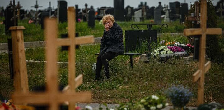 Una mujer llora mientras visita la tumba de Stanislav Hvostov, de 22 años, un militar ucraniano asesinado durante la invasión rusa de Ucrania, en la sección militar del cementerio de Kharkiv número 18 en Bezlioudivka, este de Ucrania.