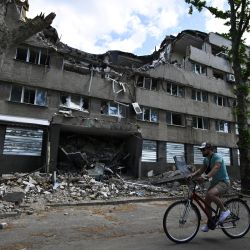 Un hombre pasa con su bicicleta por delante de un edificio del hotel Ingul, destruido por un ataque aéreo ruso en marzo de 2022, en la ciudad de Mykolaiv, al sur de Ucrania, en medio de la invasión rusa de Ucrania. | Foto:GENYA SAVILOV / AFP