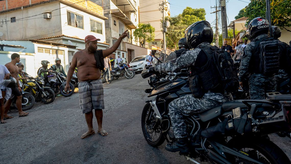 A man shouts at policemen outside the Getúlio Vargas Hospital, after a police operation at a favela, in Rio de Janeiro, Brazil, on May 24, 2022. A police raid in a Rio favela left at least 12 people dead on Tuesday, authorities said. Police said they came under gun fire as they planned to enter a slum called Vila Cruzeiro in the north of the city with the mission of locating and arresting 'criminal leaders.' In the ensuing gunbattle 11 alleged criminals died, as did a female resident of the favela who was hit by a stray bullet.  