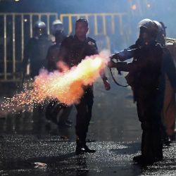 Un policía dispara un bote de gas lacrimógeno para dispersar a los manifestantes durante el 50º día de protestas antigubernamentales que exigen la dimisión del presidente de Sri Lanka, Gotabaya Rajapaksa, por la agobiante crisis económica del país, en Colombo. | Foto:ISHARA S. KODIKARA / AFP