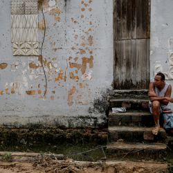 Un hombre sentado frente a una casa dañada por un deslizamiento de tierra en la comunidad Jardim Monte Verde, en Recife, estado de Pernambuco, Brasil. | Foto:BRENDA ALCANTARA / AFP