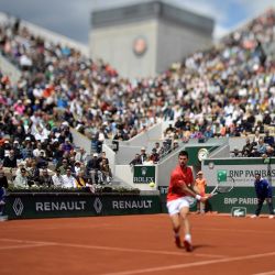El serbio Novak Djokovic juega una devolución de revés al argentino Diego Schwartzman durante su partido individual masculino en el octavo día del torneo de tenis Roland-Garros Open en la cancha Suzanne Lenglen en París. | Foto:JULIEN DE ROSA / AFP