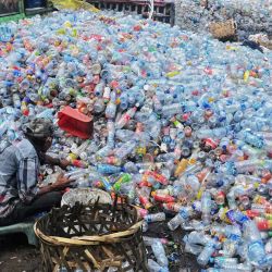 Un trabajador recoge botellas de plástico para venderlas en un vertedero en Banda Aceh, Indonesia. | Foto:CHAIDEER MAHYUDDIN / AFP
