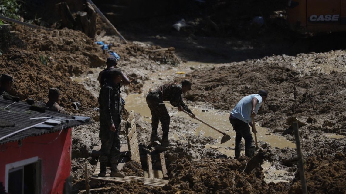 Brazilian army soldiers remove mud as they search for victims of a landslide in Recife, Pernambuco state, Brazil, on June 1, 2022.