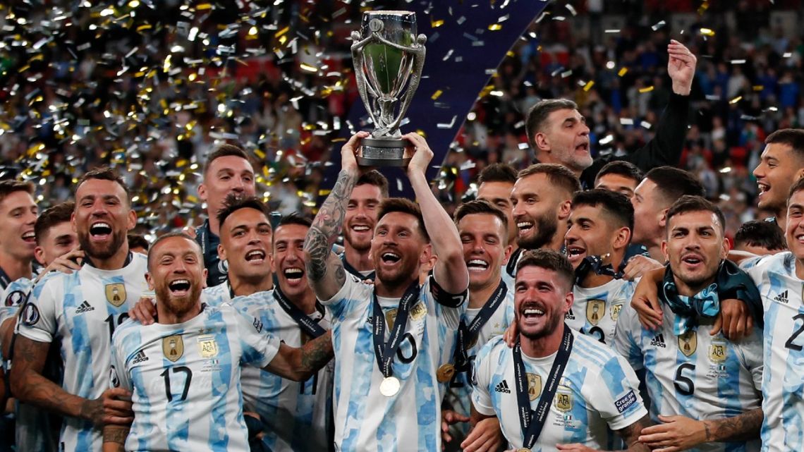 Lionel Messi lifts the trophy as Argentina's players celebrate on the pitch after their victory in the 'Finalissima' International friendly football match between Italy and Argentina at Wembley Stadium in London on June 1, 2022.