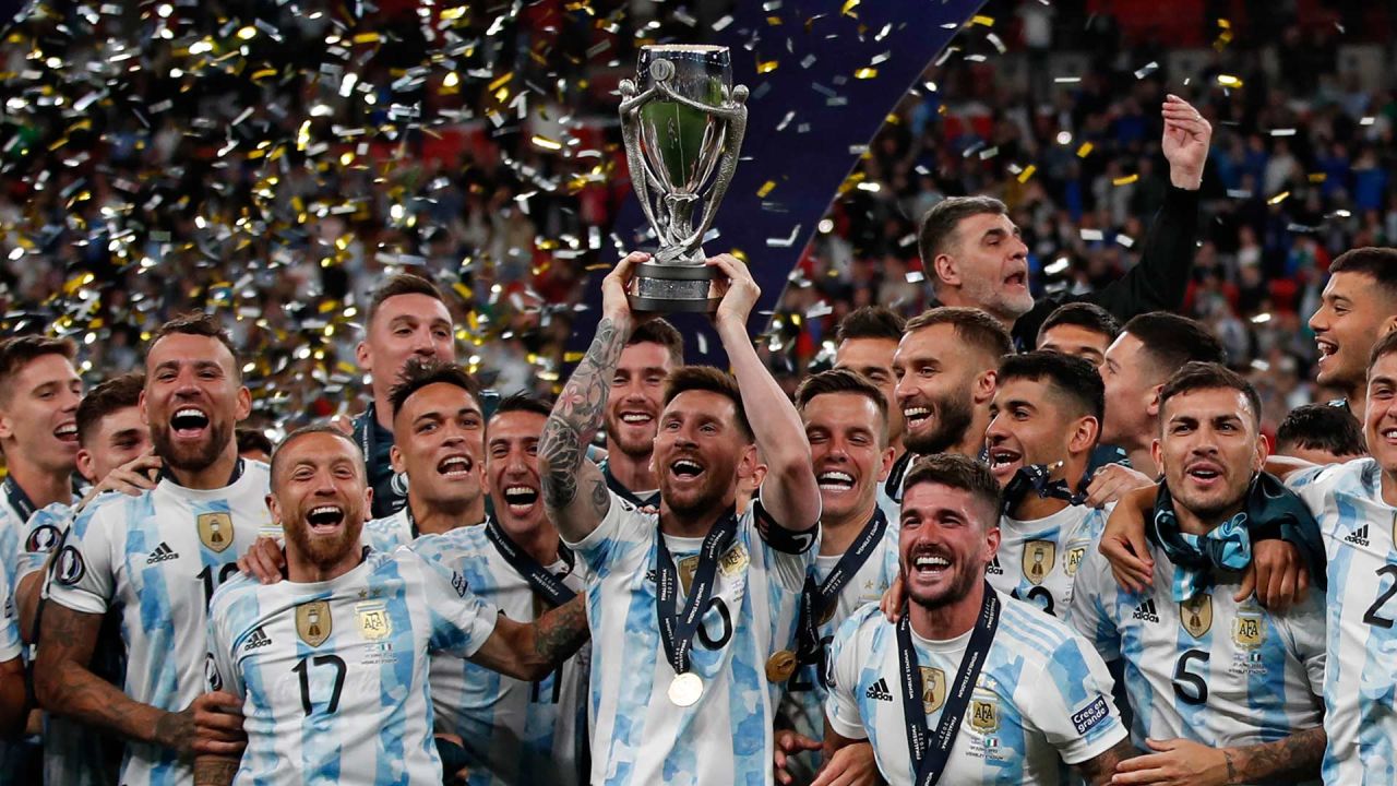 Lionel Messi levanta el trofeo mientras los jugadores de Argentina celebran en el campo después de su victoria en el partido de fútbol amistoso internacional 'Finalissima' entre Italia y Argentina en el estadio de Wembley en Londres. | Foto:ADRIAN DENNIS / AFP