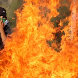 Palestinos queman neumáticos durante los enfrentamientos con las fuerzas de seguridad israelíes tras un intento de los colonos isralíes de retirar las banderas palestinas al este de la localidad cisjordana de Qalqiliya. | Foto:JAAFAR ASHTIYEH / AFP