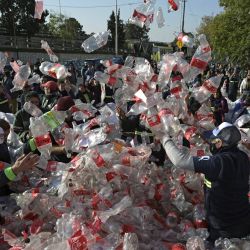 Recicladores de basura arrojan botellas de plástico vacías de Coca-Cola frente a las oficinas de Coca-Cola exigiendo una ley de reciclaje que los incluya y en contra de la financiación de los sistemas privados de reciclaje, en Buenos Aires. | Foto:JUAN MABROMATA / AFP