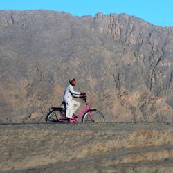 Un niño circula en bicicleta por un camino en Kandahar, Afganistán. | Foto:JAVED TANVEER / AFP