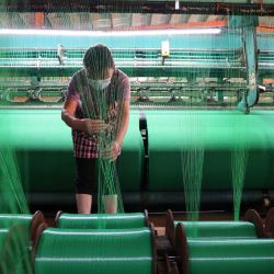 Un trabajador produce mallas de fibra en una fábrica de Binzhou, en la provincia oriental china de Shandong. | Foto:AFP