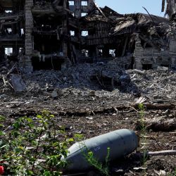 Una bomba de aviación FAB-250 no explotada es fotografiada frente a un edificio destruido en la ciudad de Mariupol, en medio de la actual acción militar rusa en Ucrania. | Foto:STRINGER / AFP