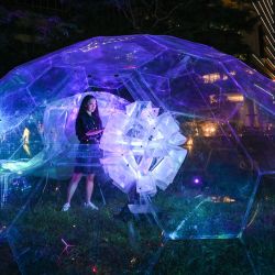Una mujer se encuentra dentro de una instalación de arte lumínico titulada Fallen, una medusa etérea de Nerdis x Artina de Corea del Sur durante la vista previa del evento - i Light Singapore en Singapur. | Foto:ROSLAN RAHMAN / AFP