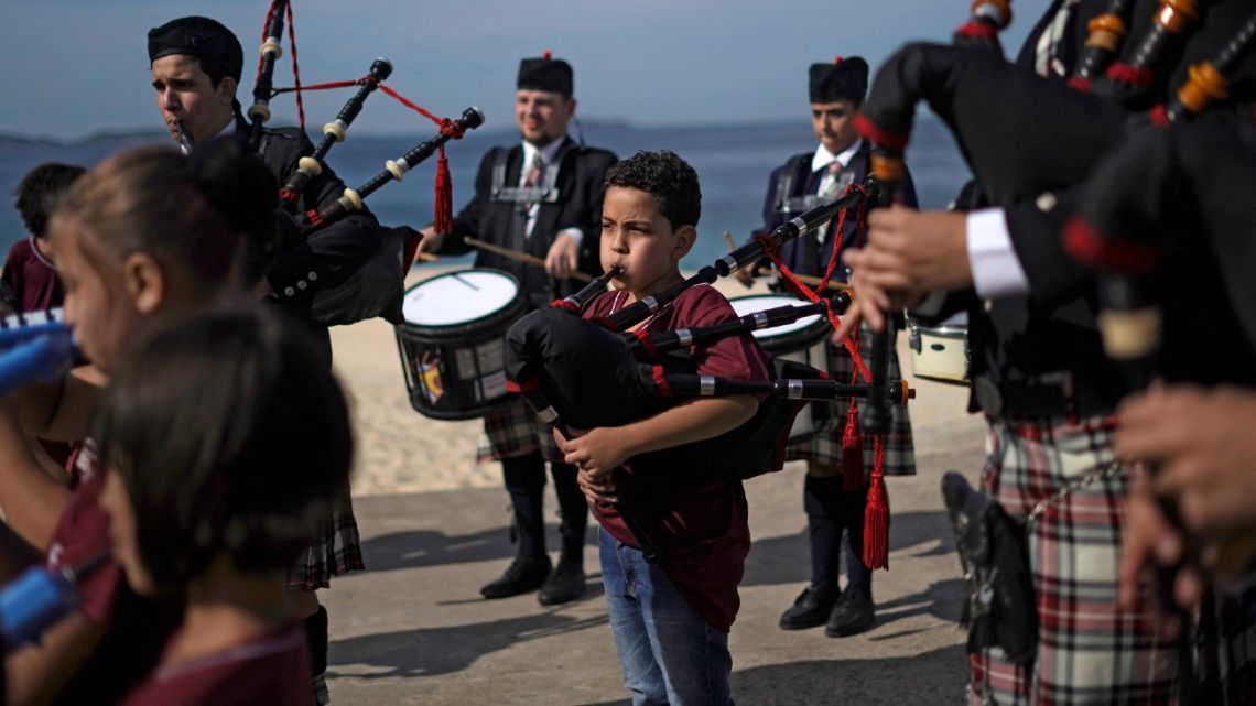 Bagpipe students, members of the Vieira Brum music band, play at the Marica beach, in Marica, Brazil, on May 28, 2022.