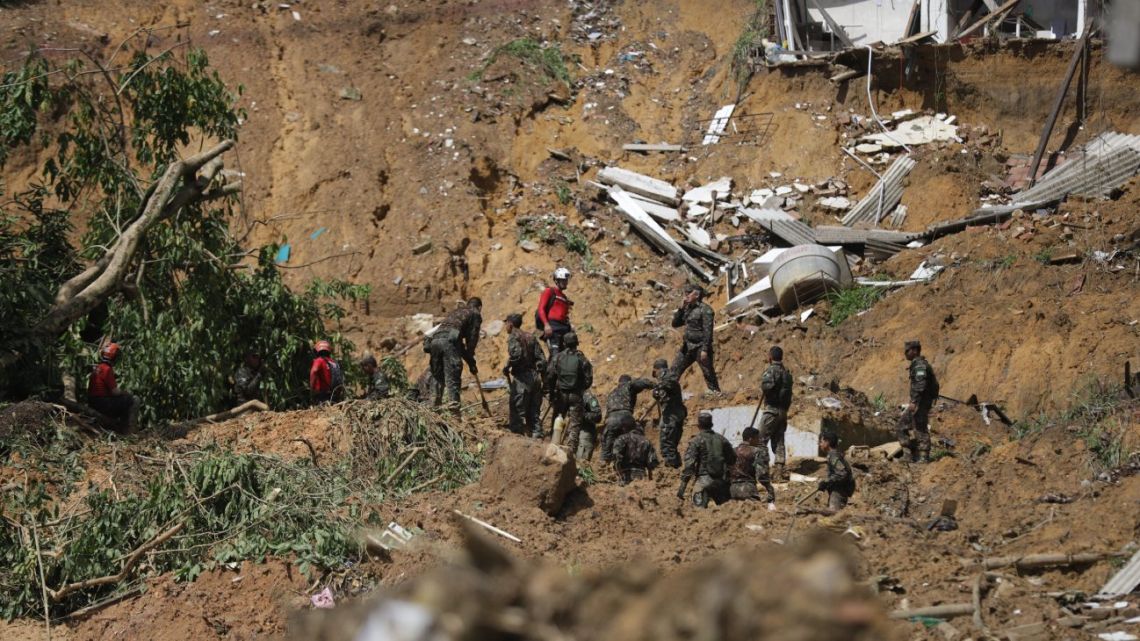 Firefighters and Brazilian Army soldiers search for victims of a landslide in the community of Bola de Ouro, Pernambuco state, Brazil, on June 1, 2022.