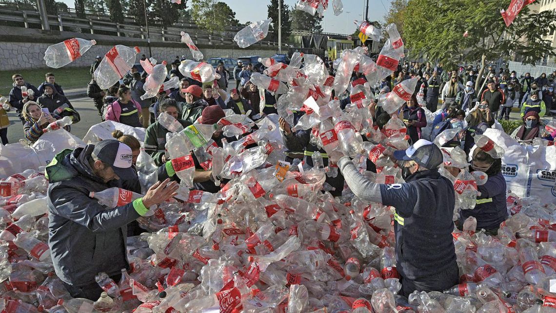 Garbage recyclers throw empty Coca-Cola plastic bottles in front of Coca-Cola's offices demanding for a recycling law that includes them and against funding for private recycling systems, in Buenos Aires on June 2, 2022.