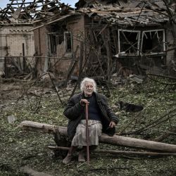 Una anciana sentada frente a las casas destruidas después de un ataque con misiles, que mató a una anciana, en la ciudad de Druzhkivka en la región oriental ucraniana de Donbas. | Foto:ARIS MESSINIS / AFP