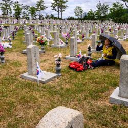 Una mujer bebe mientras realiza un brindis frente a una tumba en el Cementerio Nacional mientras Corea del Sur celebra el Día de la Memoria, que honra a los que murieron durante la Guerra de Corea de 1950-53 y en otras operaciones mientras servían a su país, en Seúl. | Foto:ANTHONY WALLACE / AFP