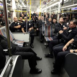 Agentes del Departamento de Policía de Los Ángeles esperan en un autobús para transportarlos al campamento de Occupy LA fuera del Ayuntamiento para desalojar a los manifestantes en Los Ángeles California. | Foto:Lucy Nicholson - Pool/Getty Images/AFP