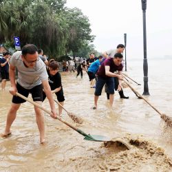 Esta foto muestra a personas limpiando una calle inundada a causa de las fuertes lluvias en Rongan, en la región de Guangxi, al sur de China. | Foto:AFP