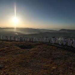 Los fieles samaritanos caminan al amanecer hacia la cima del monte Gerizim, cerca de la ciudad de Naplusa, al norte de Cisjordania, durante las celebraciones de Shavuot según la tradición samaritana, que marca la entrega de la Torá a los israelitas en el monte Sinaí siete semanas después de su éxodo bíblico de Egipto. | Foto:JAAFAR ASHTIYEH / AFP