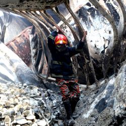 Un bombero busca personas desaparecidas en el sitio donde se registró un incendio en un depósito de contenedores, en Chattogram, Bangladesh. | Foto:Xinhua/Str