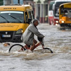 Un hombre conduce su bicicleta por una calle inundada de La Habana, tras las fuertes lluvias caídas en la isla. - Las fuertes lluvias de los restos del huracán Agatha inundaron gran parte del oeste de Cuba la semana pasada, matando al menos a tres personas en La Habana. | Foto:YAMIL LAGE / AFP