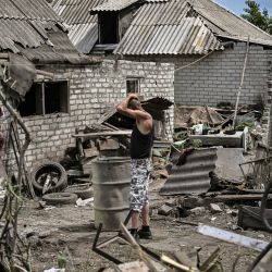 Maksym Katerin se encuentra en el patio de su casa dañada después de que su madre y su padrastro murieran durante un bombardeo en la ciudad de Lisychansk, en la región oriental ucraniana de Donbas, en medio de la invasión rusa de Ucrania. | Foto:ARIS MESSINIS / AFP