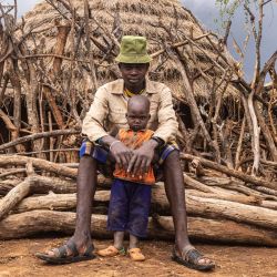 Un hombre Karamojong posa con su hijo en Kotirae, región de Karamoja, Uganda. - Más de medio millón de personas pasan hambre en la región ugandesa de Karamoja, un 40% de la población total que sobrevive en una región a menudo olvidada entre Sudán del Sur y Kenia. | Foto:BADRU KATUMBA / AFP