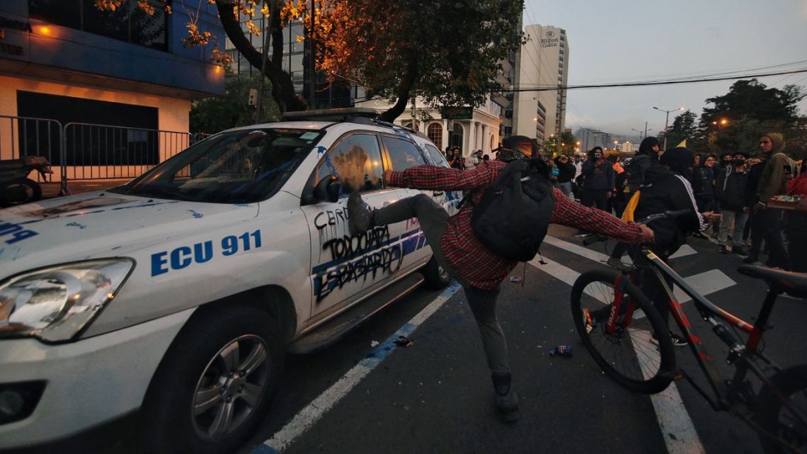 University students vandalise a vehicle of the National Police outside the Judicial Unit of Flagrancy, in Quito, on 14 June, 2022, during a demonstration against the government of President Guillermo Lasso in the framework of indigenous-led protests that 