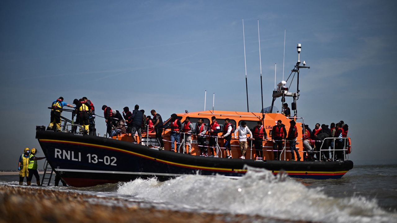 Migrantes, recogidos en el mar al intentar cruzar el Canal de la Mancha, son ayudados a desembarcar desde un bote salvavidas de la Royal National Lifeboat Institution (RNLI) en Dungeness, en la costa sureste de Inglaterra. | Foto:Ben Stansall / AFP