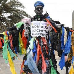 El activista senegalés Modou Fall, llamado el hombre de plástico, presidente de la asociación Senegal Propre (Senegal Limpio), es visto a la entrada de Pikine, un suburbio de Dakar. | Foto:SEYLLOU / AFP