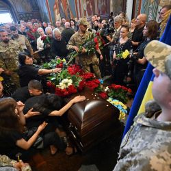 Familiares y amigos reaccionan ante el féretro de Volodymyr Primachenko, combatiente del batallón Aidar, de las Fuerzas Armadas de Ucrania, y participante de la Revolución de la Dignidad del Maidán, durante un servicio fúnebre en la catedral de Mykhaylo Golden Doms en Kiev, en medio de la invasión rusa de Ucrania. | Foto:SERGEI SUPINSKY / AFP