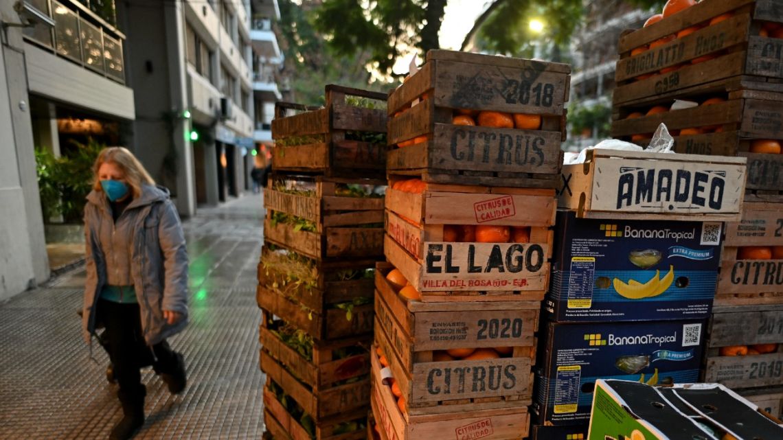 A woman walks past boxes of fruit in Buenos Aires, on June 15, 2022.