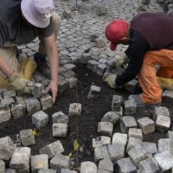 Workers restore cobblestones on a street in the San Telmo neighbourhood of Buenos Aires on April 25, 2022.