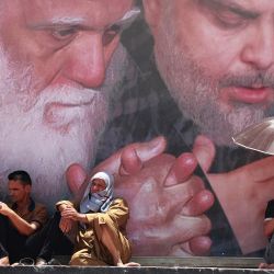 Partidarios del clérigo chiíta iraquí Muqtada al-Sadr (retratado) asisten a las oraciones del viernes en Ciudad Sadr, al este de la capital, Bagdad. | Foto:AHMAD AL-RUBAYE / AFP