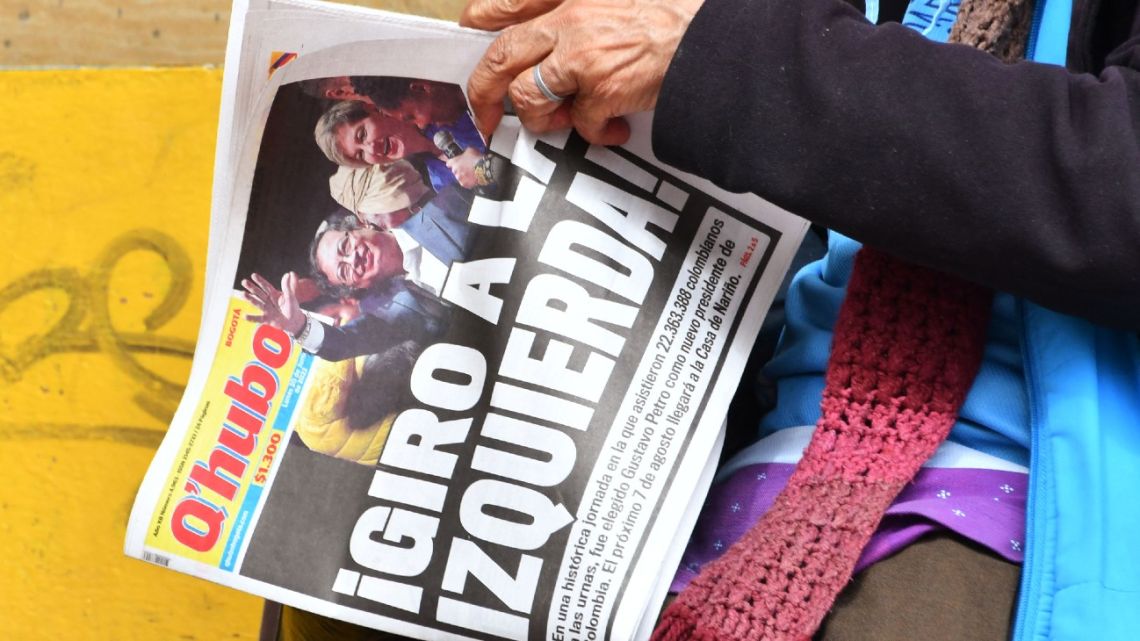 A woman holds a local newspaper which front page reads “Turn to the left!” the day after the presidential candidate for the Historic Pact coalition, Gustavo Petro, was elected president on a tense election, in Bogotá, on June 20, 2022. 