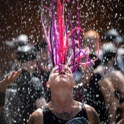 Un asistente al festival se refresca con agua mientras participa en el festival de música metal Hellfest en Clisson, al oeste de Francia. | Foto:LOIC VENANCE / AFP