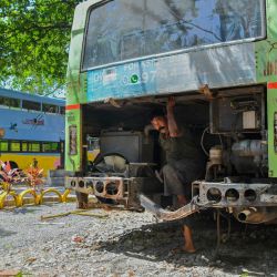 Un mecánico trabaja en un antiguo autobús de transporte público de piso bajo que se está transformando en un aula para niños de preescolar a través de una iniciativa "Educación sobre ruedas" adoptada por el gobierno estatal en Thiruvananthapuram, en el estado indio de Kerala. | Foto:Manjunath Kiran / AFP