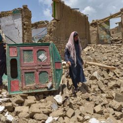 Hombres afganos buscan sus pertenencias entre las ruinas de una casa dañada por un terremoto en el distrito de Bernal, provincia de Paktika. | Foto:AHMAD SAHEL ARMAN / AFP