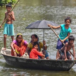 Los aldeanos viajan en un bote en las aguas de la inundación en la aldea de Hatibhangi en el distrito de Morigaon, en el estado indio de Assam. | Foto:BIJU BORO / AFP