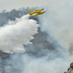 Un avión de extinción de incendios AT-802A lanza agua durante las operaciones de contención del fuego cerca de Artesa de Segre, en Cataluña, España. | Foto:PAU BARRENA / AFP