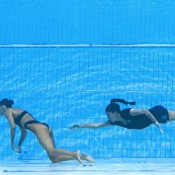 Un miembro del equipo de Estados Unidos nada para recuperar a la estadounidense Anita Álvarez, desde el fondo de la piscina durante un incidente en la final de natación artística libre femenina, durante los Campeonatos Mundiales Acuáticos de Budapest 2022. | Foto:OLI SCARFF / AFP