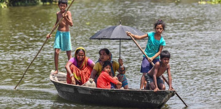 Los aldeanos viajan en un bote en las aguas de la inundación en la aldea de Hatibhangi en el distrito de Morigaon, en el estado indio de Assam.