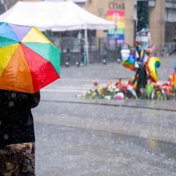 Una mujer se refleja de la lluvia bajo un paraguas de color arco iris mientras camina junto al monumento en el sitio en Oslo Noruega, donde dos personas se dispararon en un ataque contra varios bares. Beate Oma Dahle / AFP | Foto:AFP