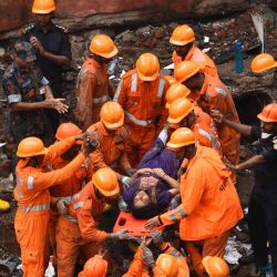 Los equipos de rescate aplauden cuando un sobreviviente es sacado con vida en una camilla de los escombros de un edificio derrumbado en Mumbai. Imtiyaz SHAIKH / AFP | Foto:AFP