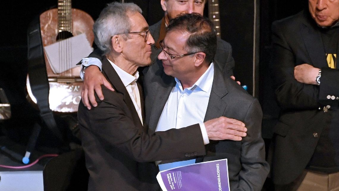 Colombia's president-elect Gustavo Petro (right) embraces the president of Colombia's Truth Commission, Francisco de Roux, during the presentation of their final report on the Colombian decades-long armed conflict, at the Jorge Eliecer Gaitan theatre in Bogota, on June 28, 2022. 