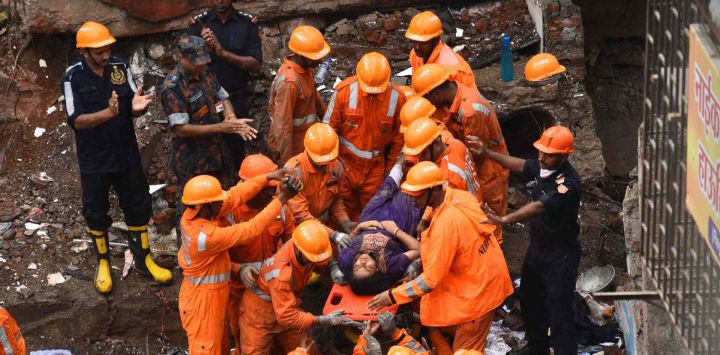 Los equipos de rescate aplauden cuando un sobreviviente es sacado con vida en una camilla de los escombros de un edificio derrumbado en Mumbai. Imtiyaz SHAIKH / AFP
