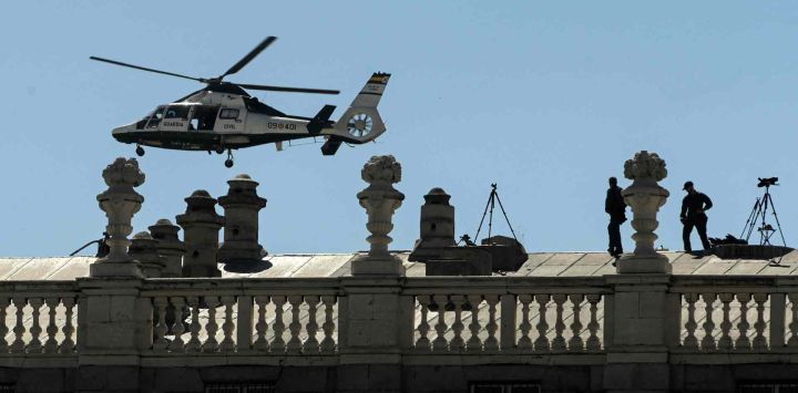 Un helicóptero Eurocopter AS365 "Dauphin" de la Guardia Civil española sobrevuela a los agentes que montan guardia en la azotea del Palacio Real de Madrid, durante la cumbre de la OTAN. ÓSCAR DEL POZO / AFP